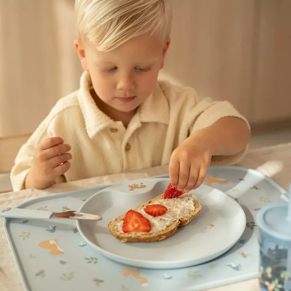Bambino mangia dal piatto poggiato sulla Tovaglietta Rigida Little Dutch Forest Friends