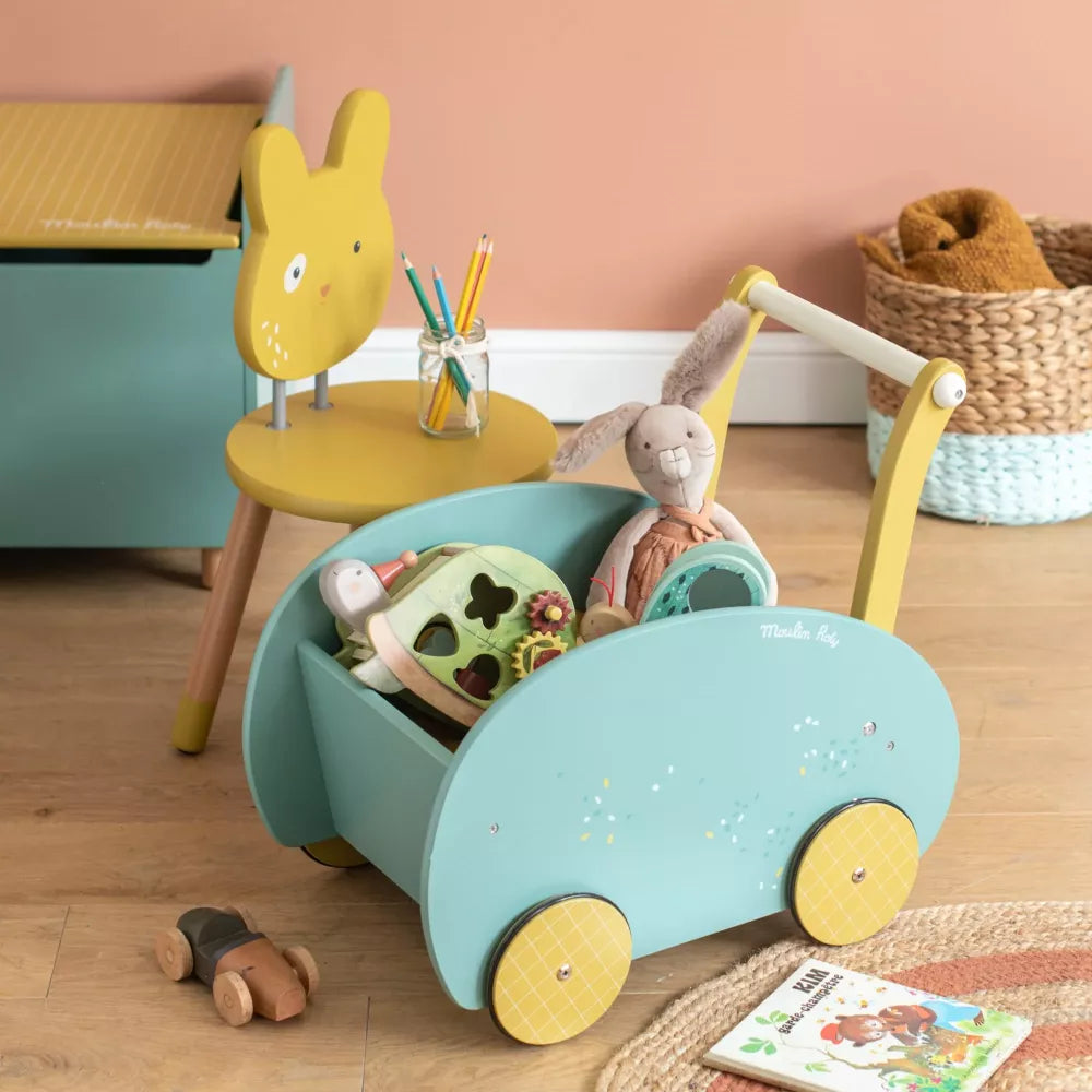 Esempio Carrello Primipassi Moulin Roty Trois Petits Lapins pieno di giocattoli