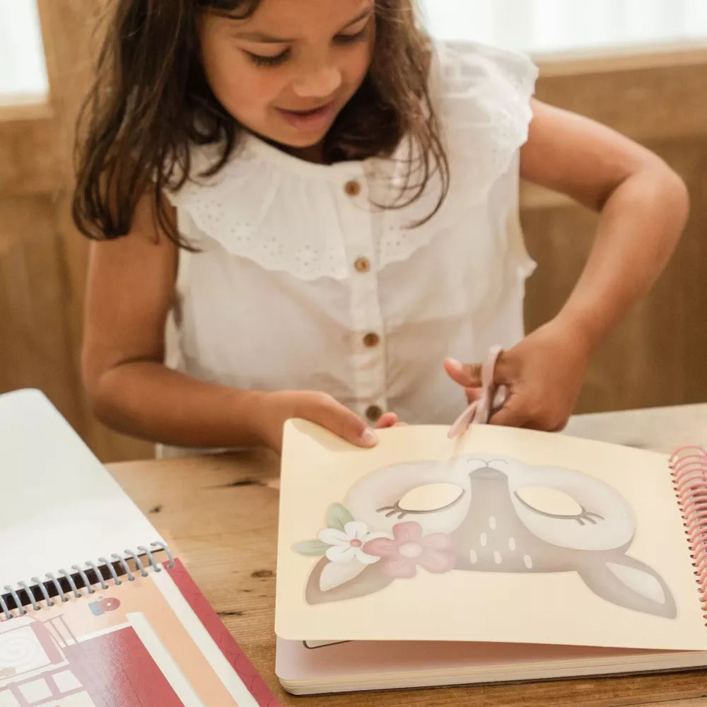 Bambina ritaglia una maschera dal Libro con Forbici Le Maschere di Rosa Little Dutch
