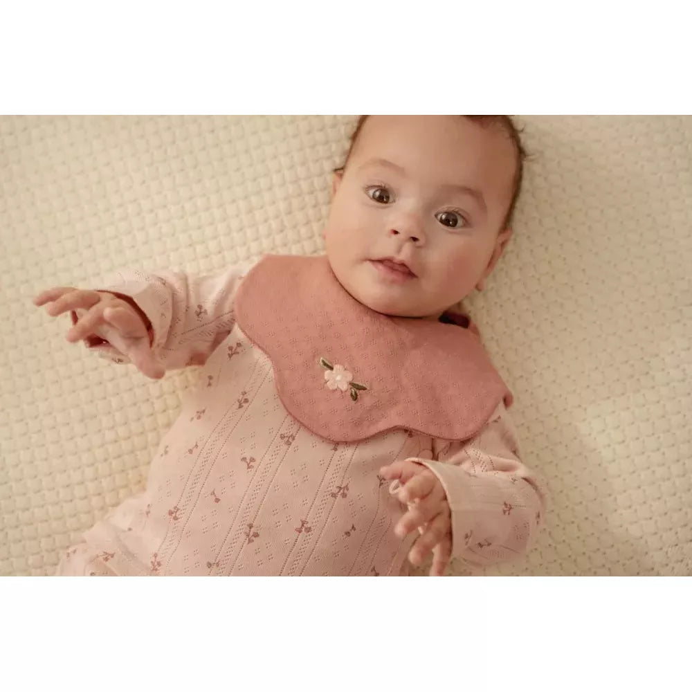Bambina indossa il bavaglino rosa del Set Bavaglini Fiore Rosa Little Dutch