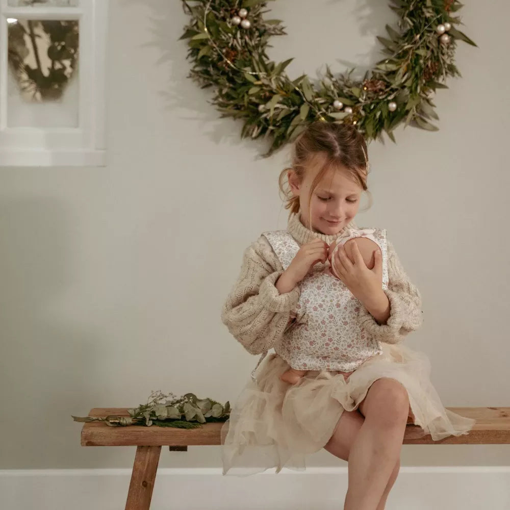 Bambina seduta trasporta una bambola con il Marsupio per Bambole Little Dutch