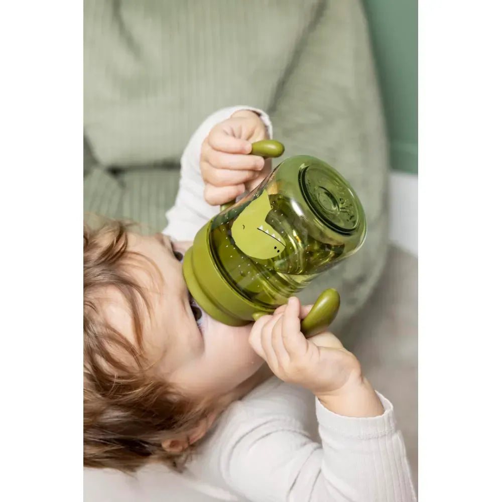 Bambino che beve dalla Tazza d'Apprendimento Antigoccia Trixie Mr. Dino